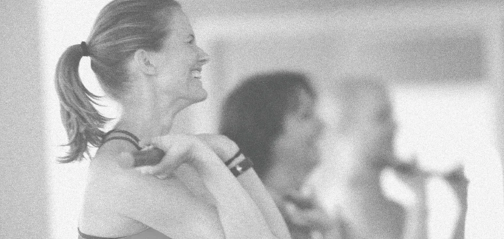 Member smiling mid-exercise with a resistance band