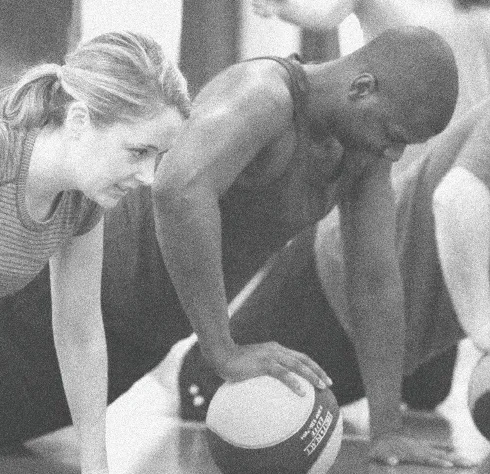 Two members working medicine-ball push-ups side by side