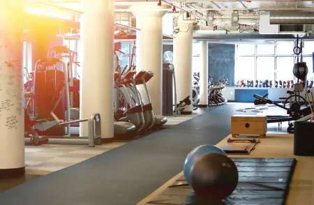 Cardio floor with treadmills and stability balls beneath high ceilings