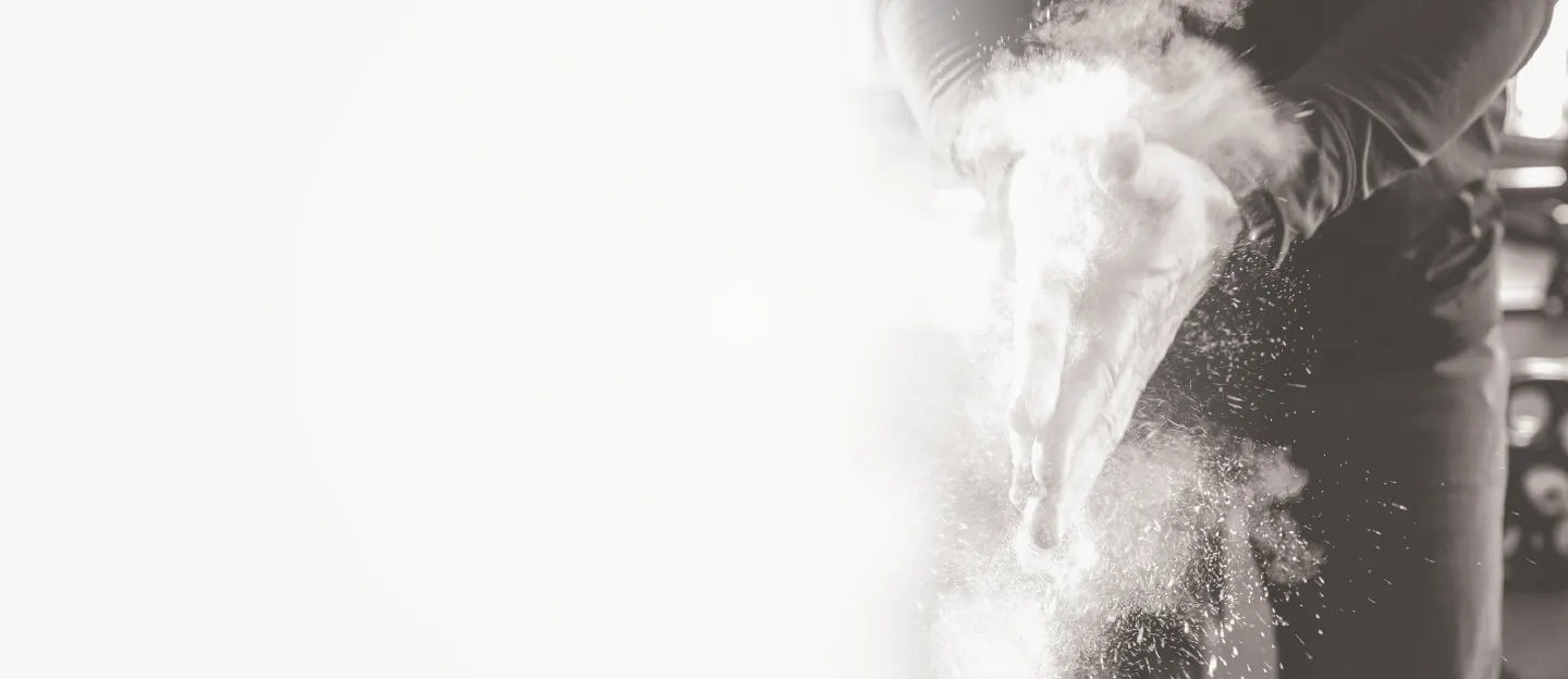 Chalk dust flying from a lifter clapping their hands