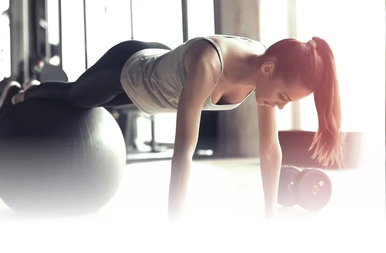 Member doing a plank on a stability ball at ZUM Fitness
